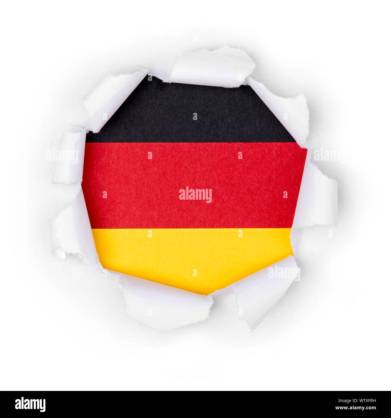 View of the german flag through the big breakthrough in the paper. Stock Photo