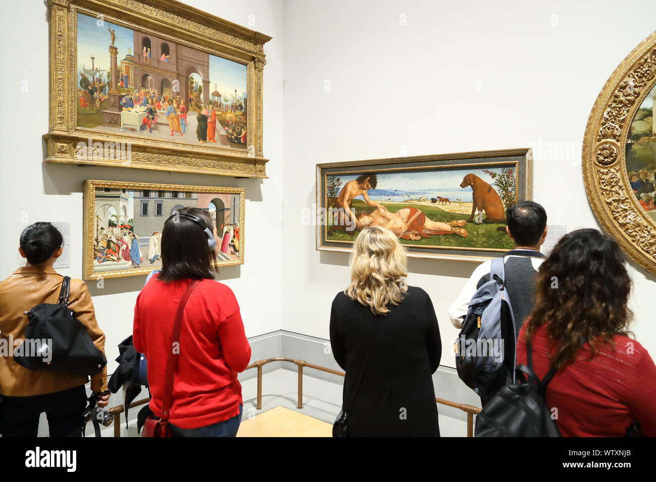Visitors studying the painting A Satyr mourning over a Nymph by Italian Renaissance painter Piero di Cosimo at the National Gallery, London, UK Stock Photo