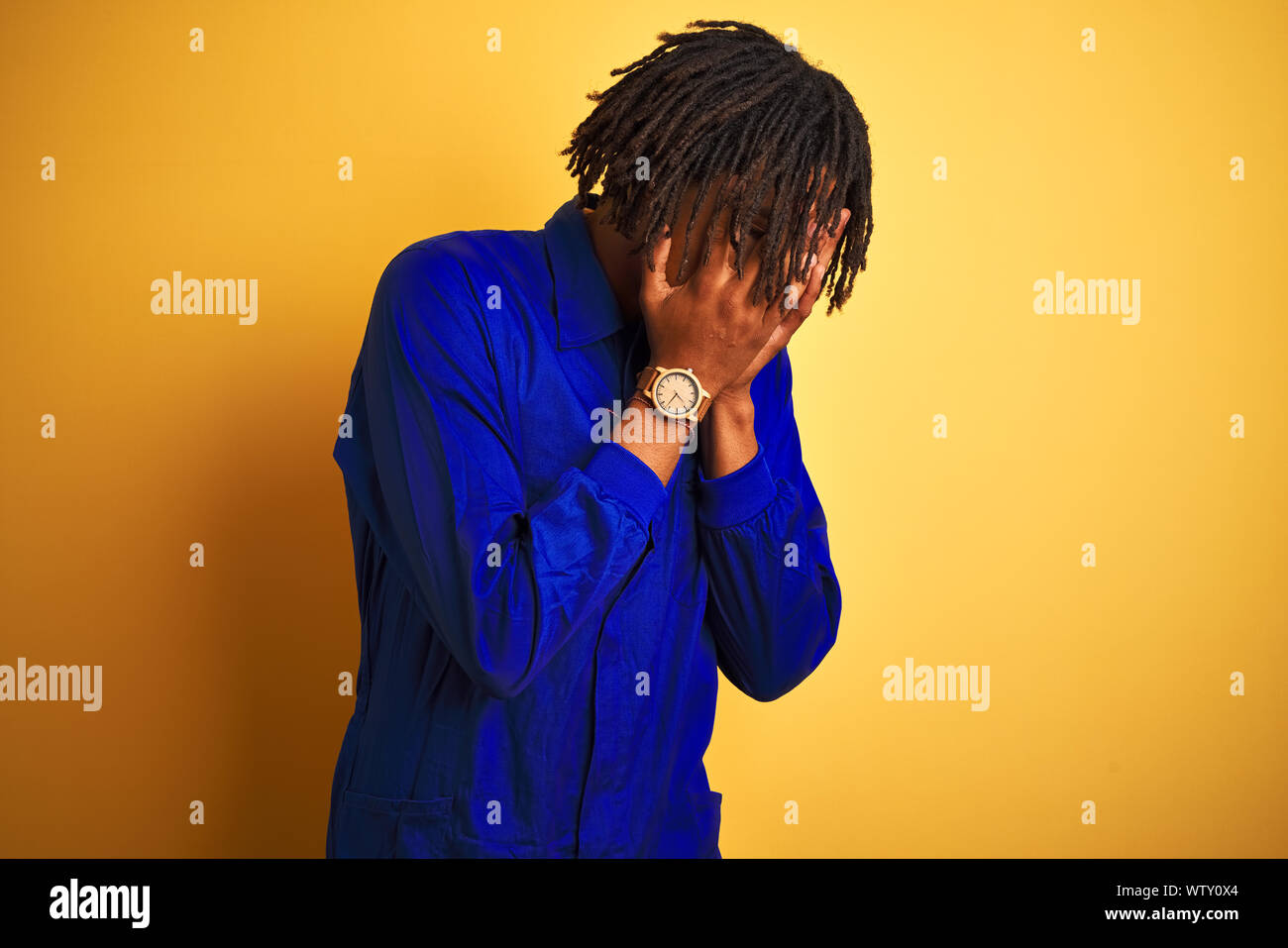 Afro worker man with dreadlocks wearing mechanic uniform over isolated ...