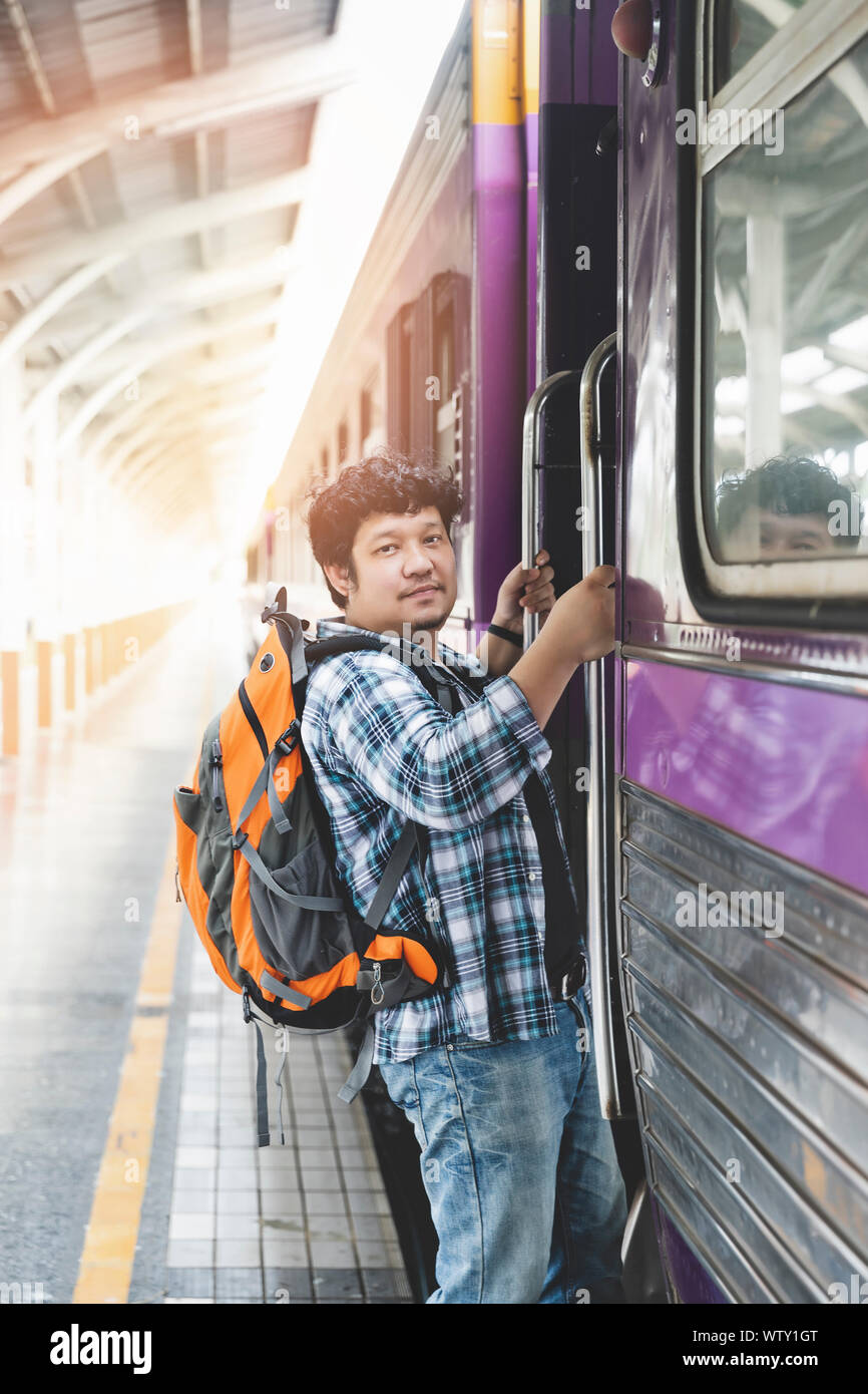 Asian man traveler with backpack is stepping up the train in train ...