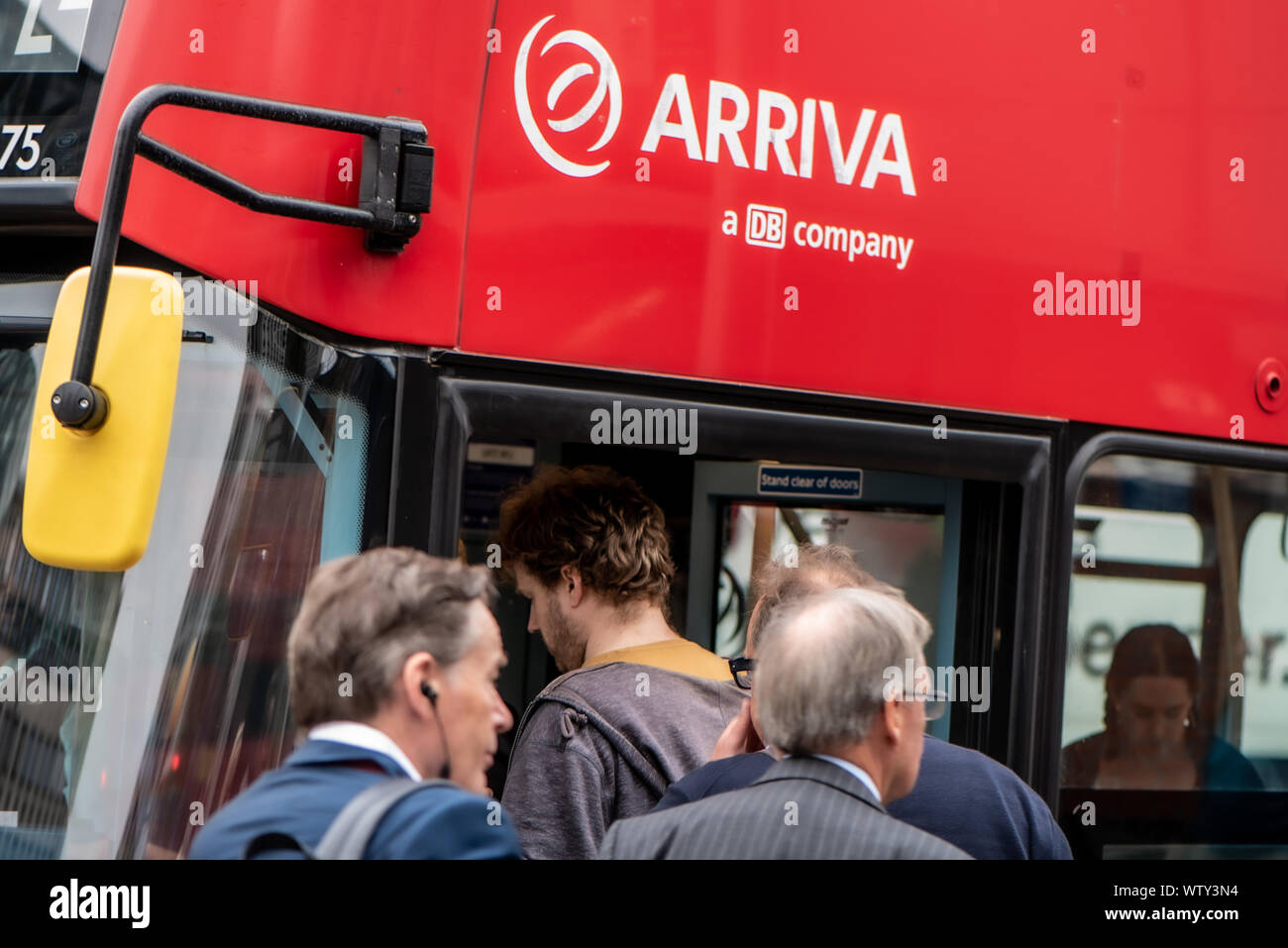 London commuters board a red Arriva bus at Waterloo Station, London, UK Stock Photo
