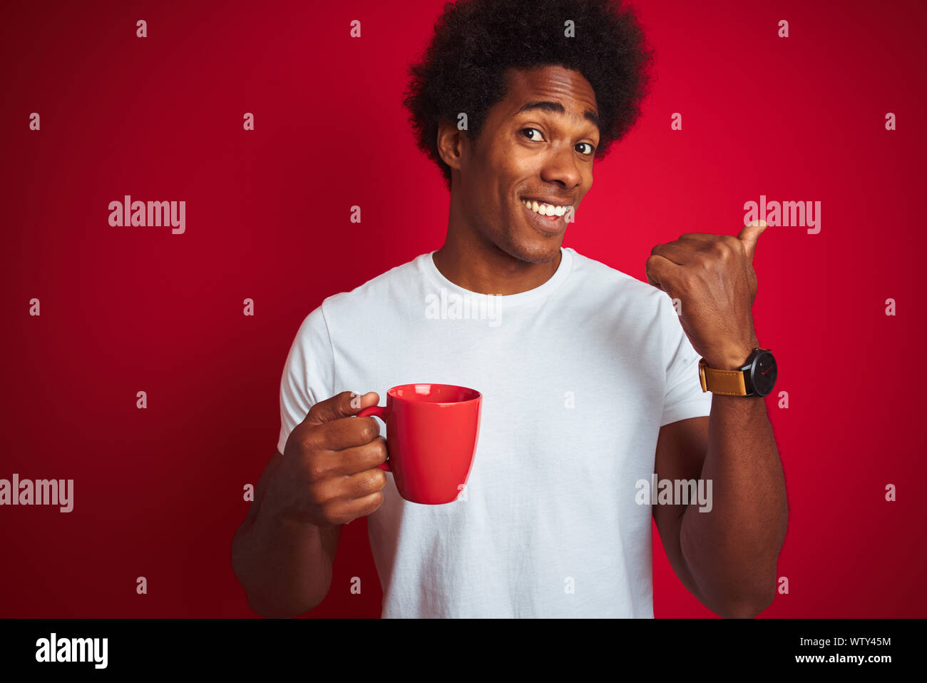 Young african american man drinking a cup of coffee standing over ...