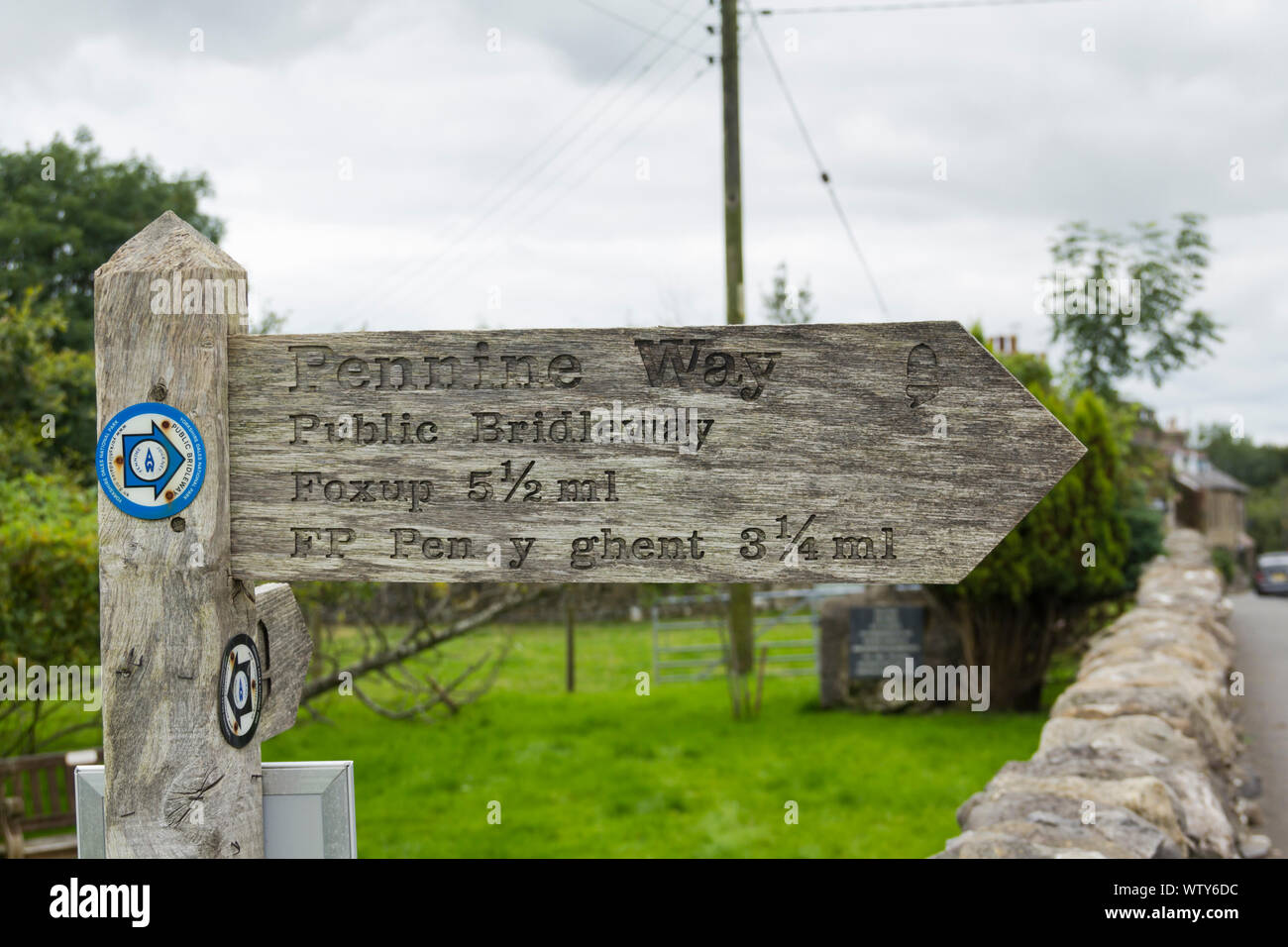 Sign indicating the route of the Pennine Way long distance footpath in the village of Horton-in-Ribblesdale, North Yorkshire on a dull, cloudy day. Stock Photo