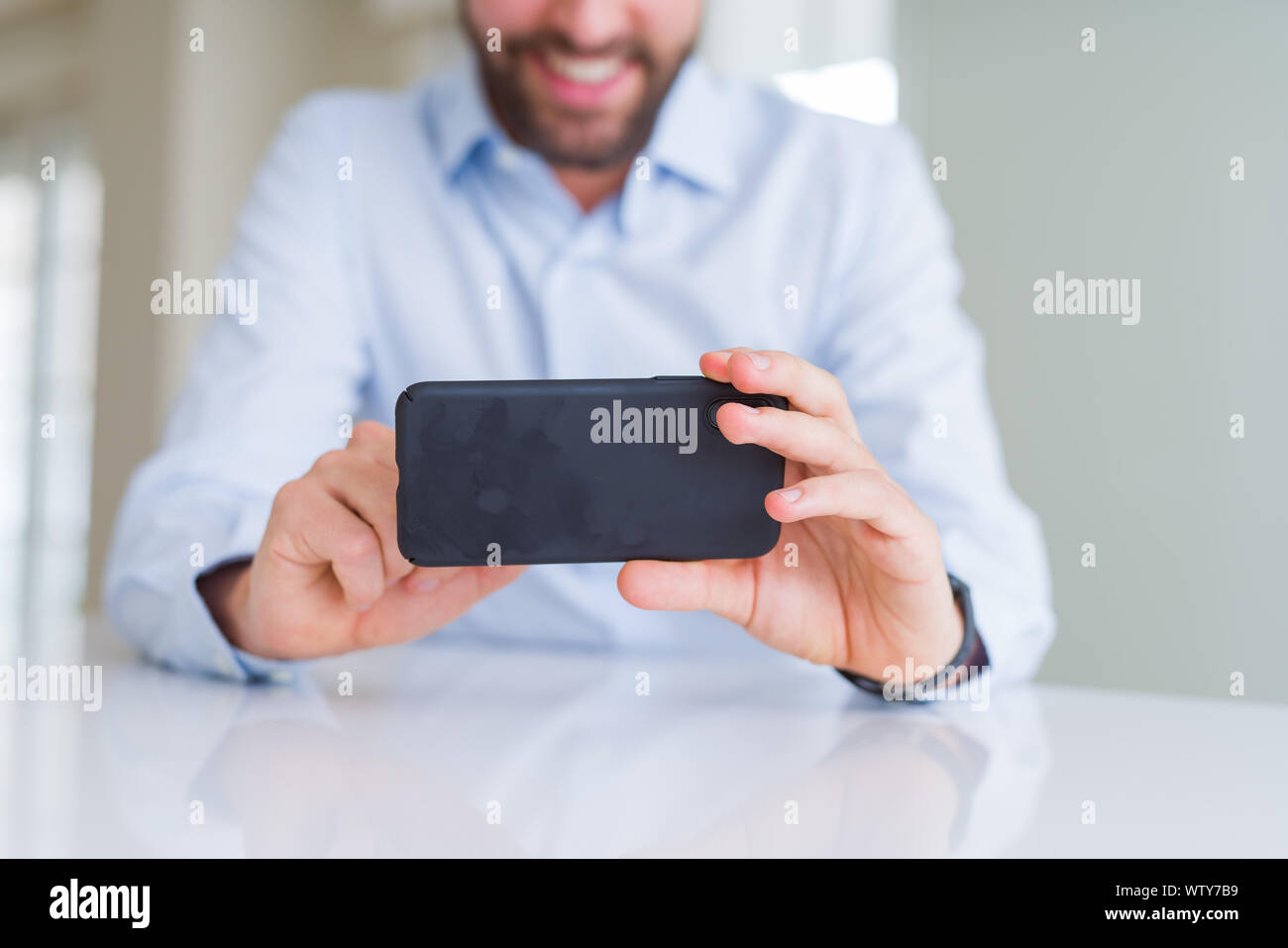 Close up of man hands using smartphone and smiling Stock Photo - Alamy