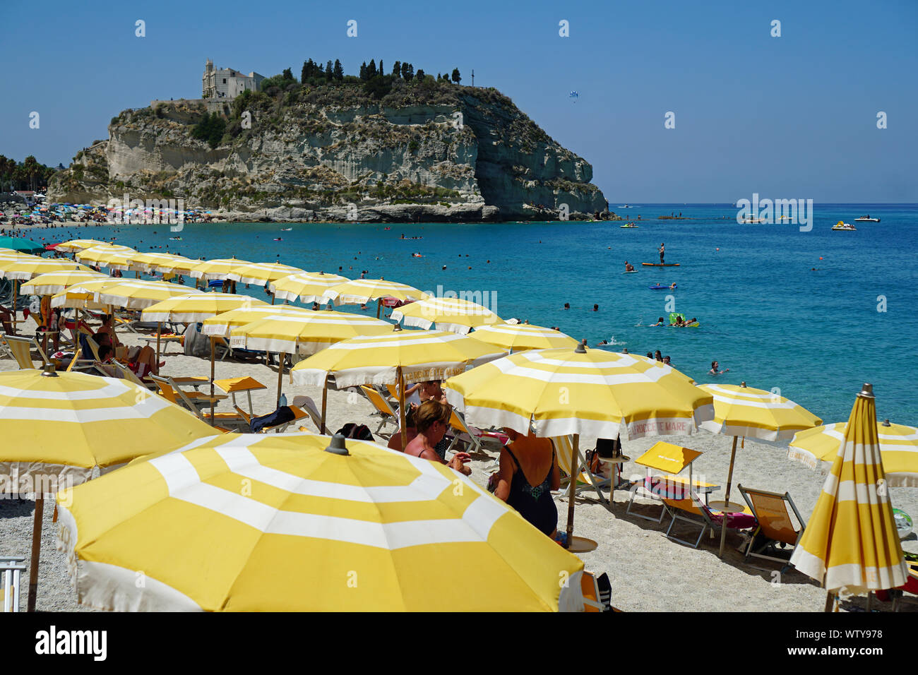 The public beach in Tropea, Calabria, Italy. View from the south August 2019. On the hill at the back is built the Church of Santa Maria dell'Isola. Stock Photo