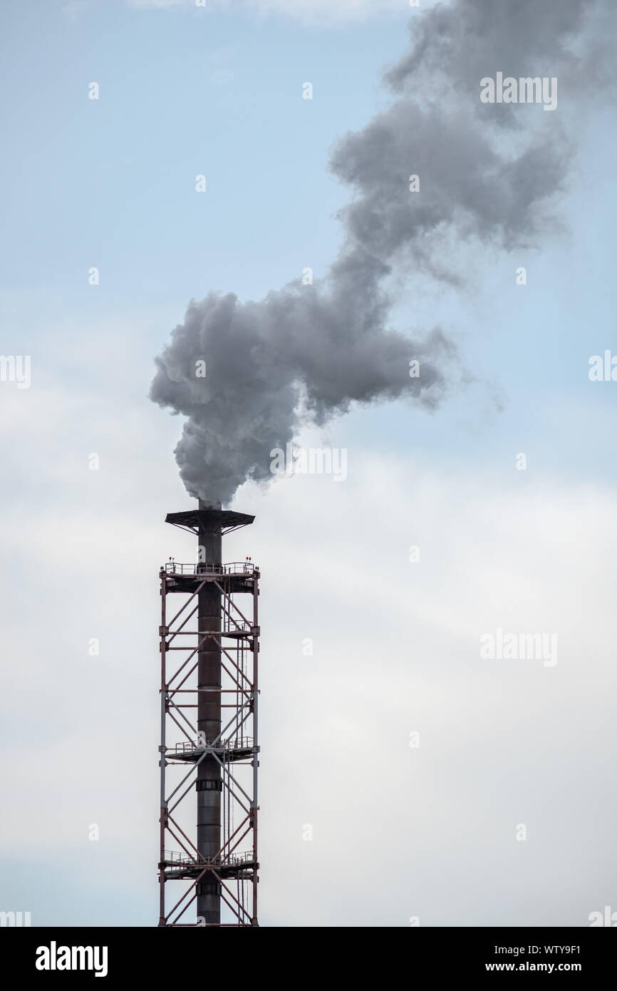 Industrial pipe against the sky, emitting harmful toxic emissions into the atmosphere. Inefficient production is destructive to nature. Stock Photo