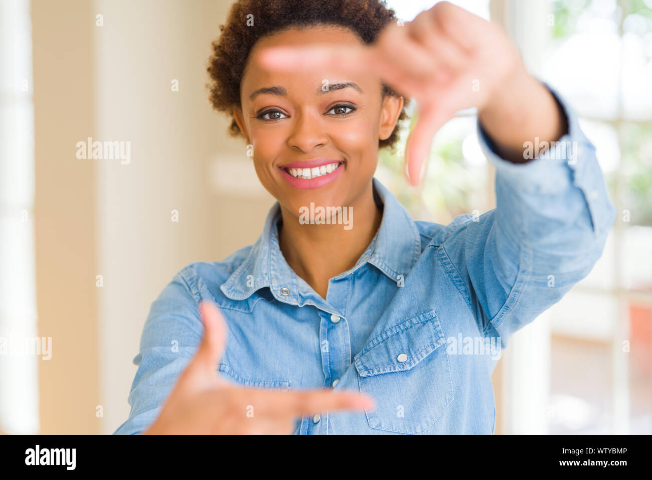 Young beautiful african american woman smiling making frame with hands ...