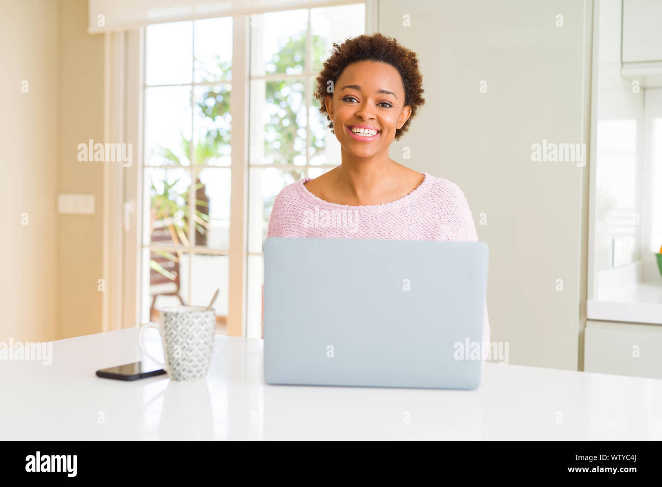 Young african american woman working using computer laptop with a happy ...