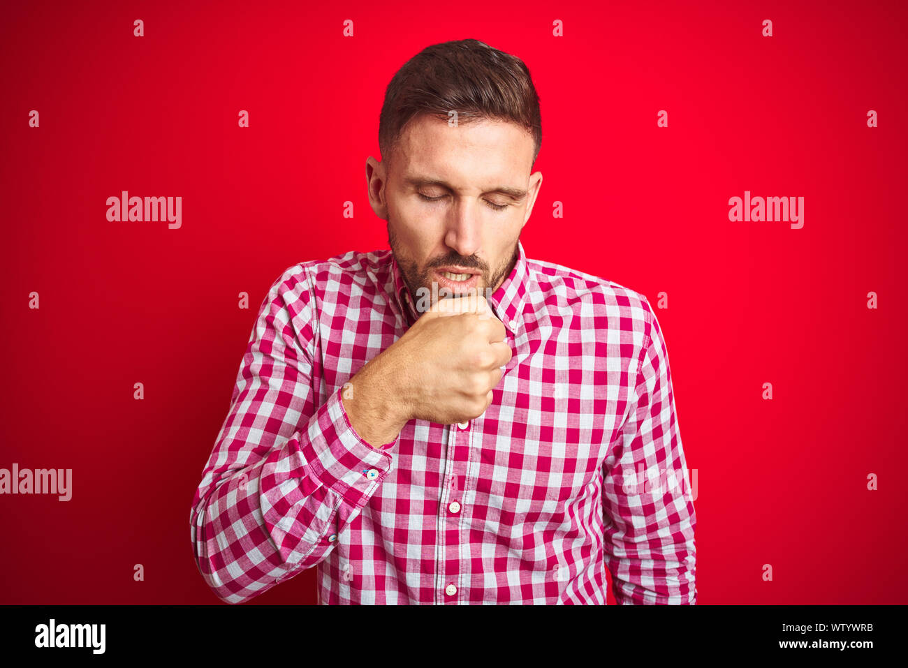 Young handsome man over red isolated background feeling unwell and