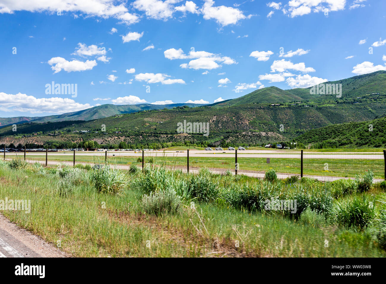 Aspen, USA - July 3, 2019: Town in Colorado with small airport in famous city during summer day with fence by road and mountains Stock Photo