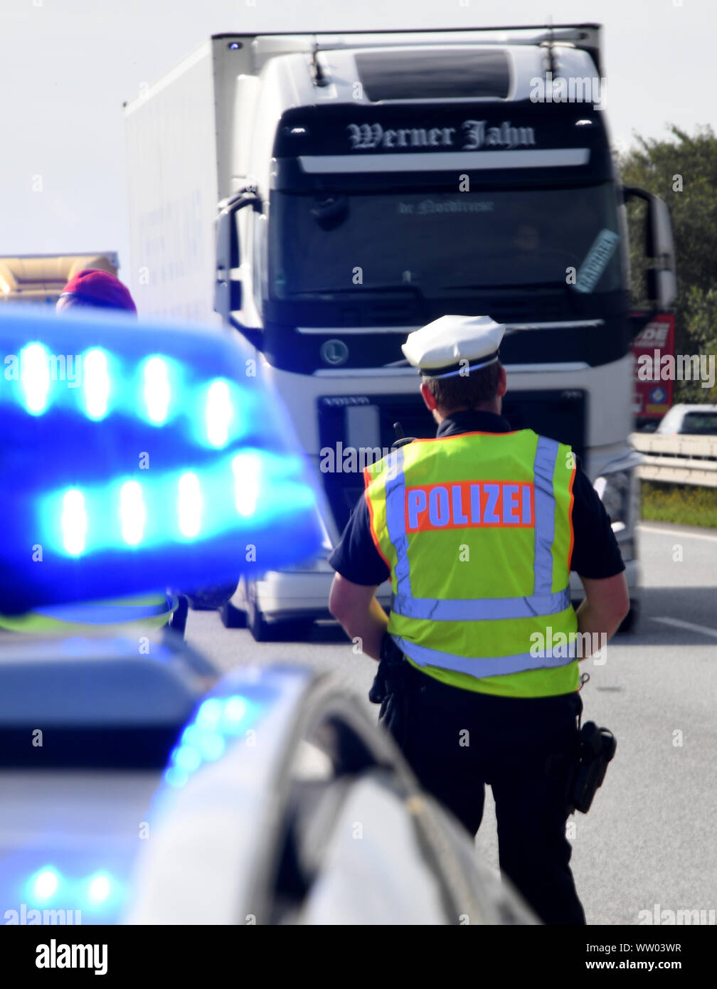 Jalm, Germany. 12th Sep, 2019. A policeman stands at a checkpoint on the Autobahn 7. Focus checks of trucks have begun throughout Germany. Several thousand policemen, customs officers and soldiers are deployed for this purpose. They check drivers' adherence to driving and rest times, the technical condition of the vehicles and the securing of the load. Credit: Carsten Rehder/dpa/Alamy Live News Stock Photo