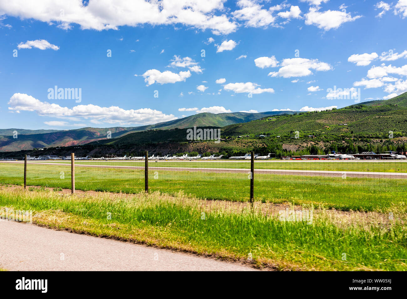 Aspen, USA - July 3, 2019: Colorado small airport in famous city during summer day with fence by road and mountains Stock Photo