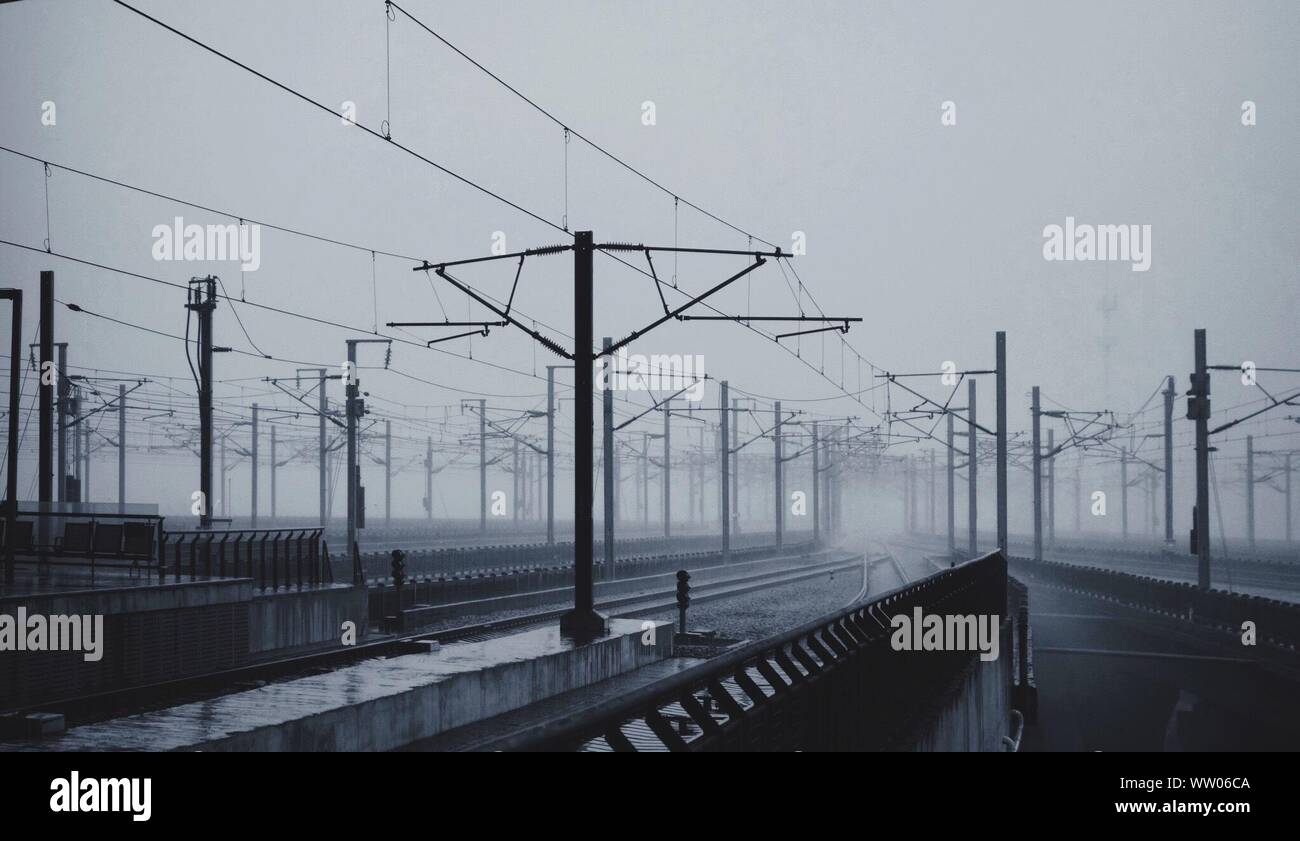 Railroad Tracks On Field In Foggy Weather Stock Photo Alamy