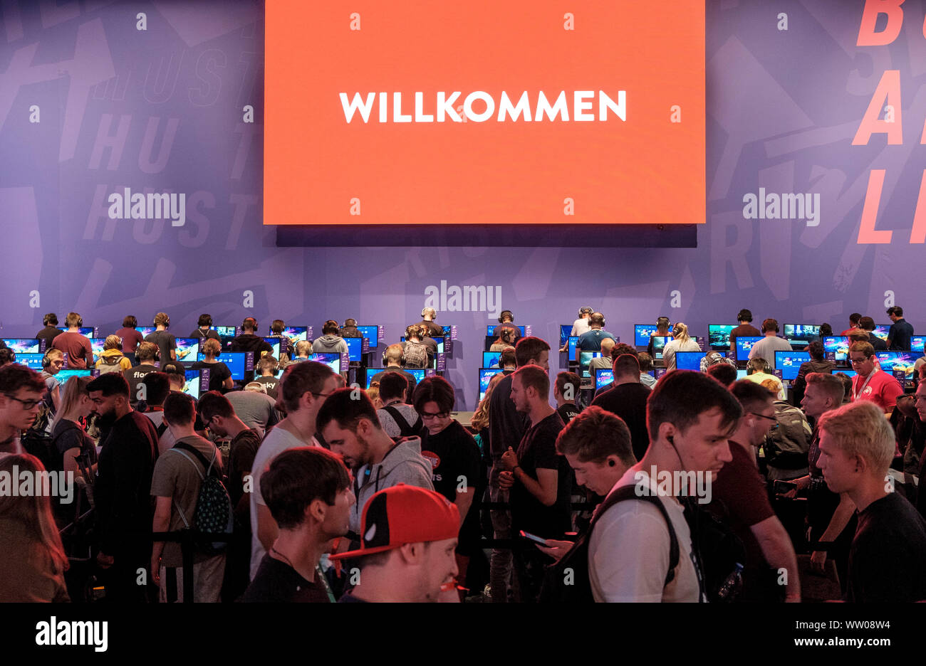 visitors play car racing game below large screen displaying the word