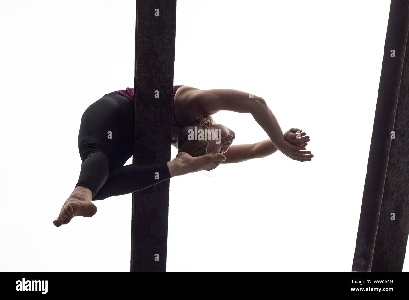 Low Angle View Of Gymnast Performing On Balance Beam Against Clear Sky Stock Photo