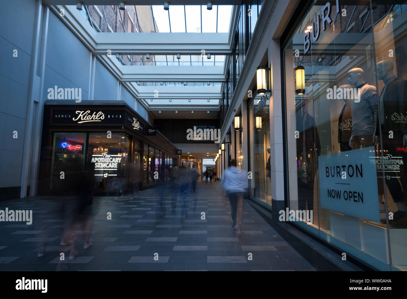 Daytime long exposure of people walking past a Burton store front in Liverpool One. Stock Photo