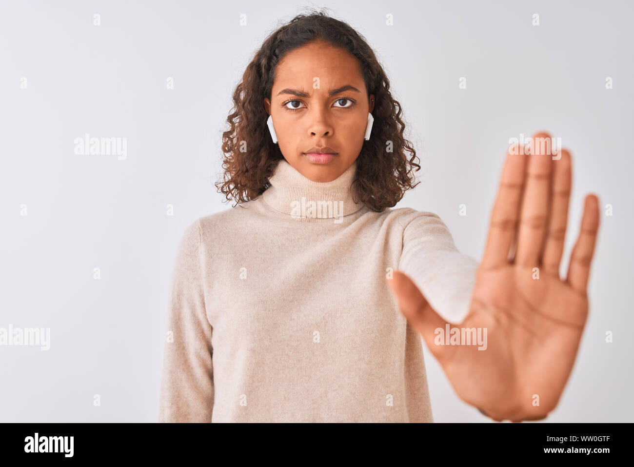 Brazilian woman listening to music using wireless earphones over