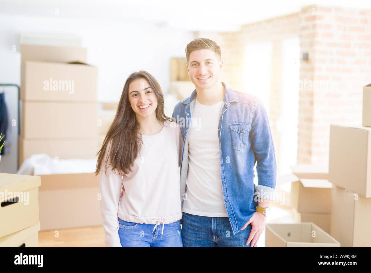 Beautiful young couple moving to a new home, standing on new aparment ...