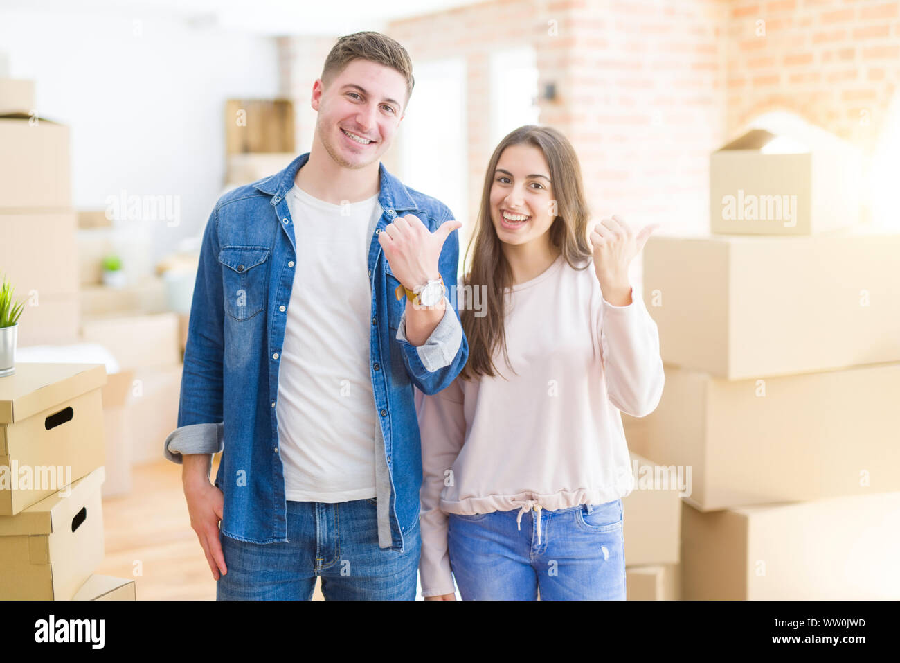 Beautiful young couple moving to a new house smiling with happy face ...
