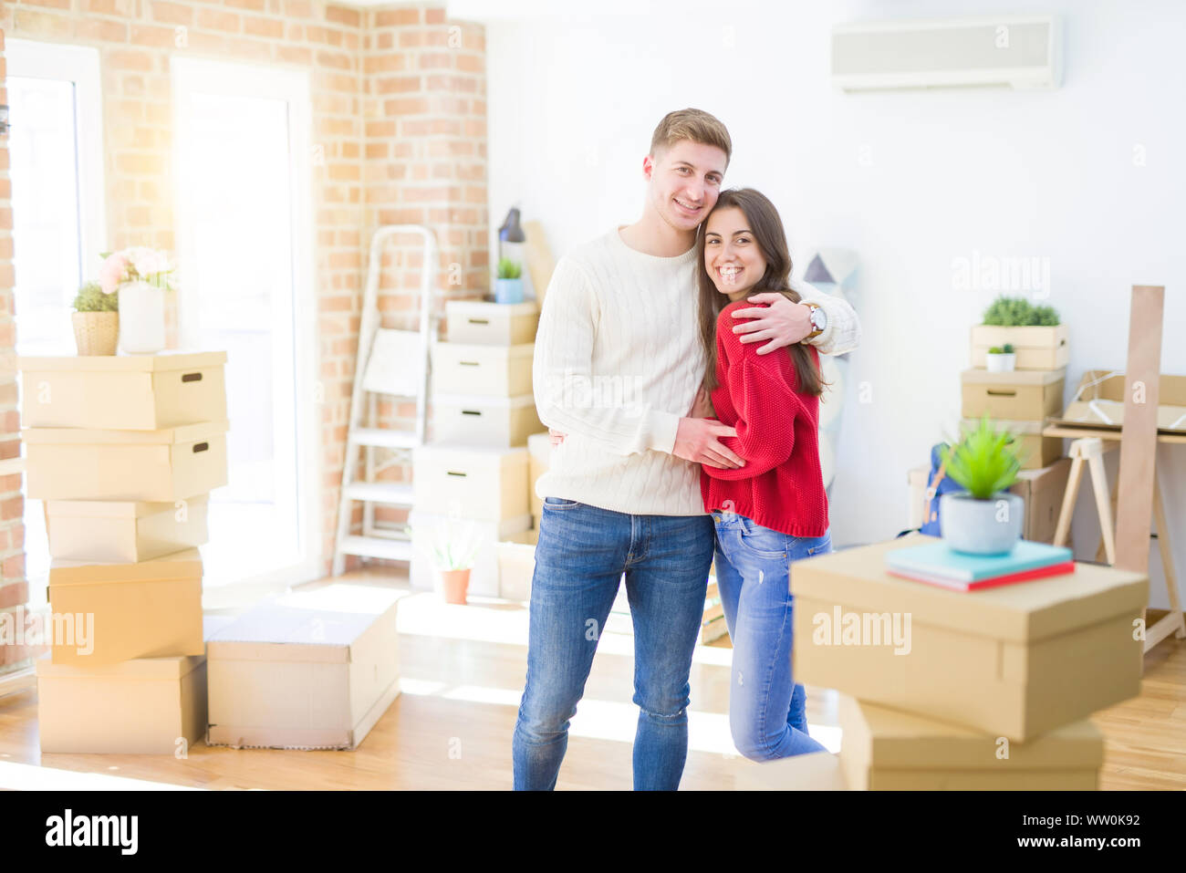 Beautiful young couple moving to a new home, standing on new aparment ...