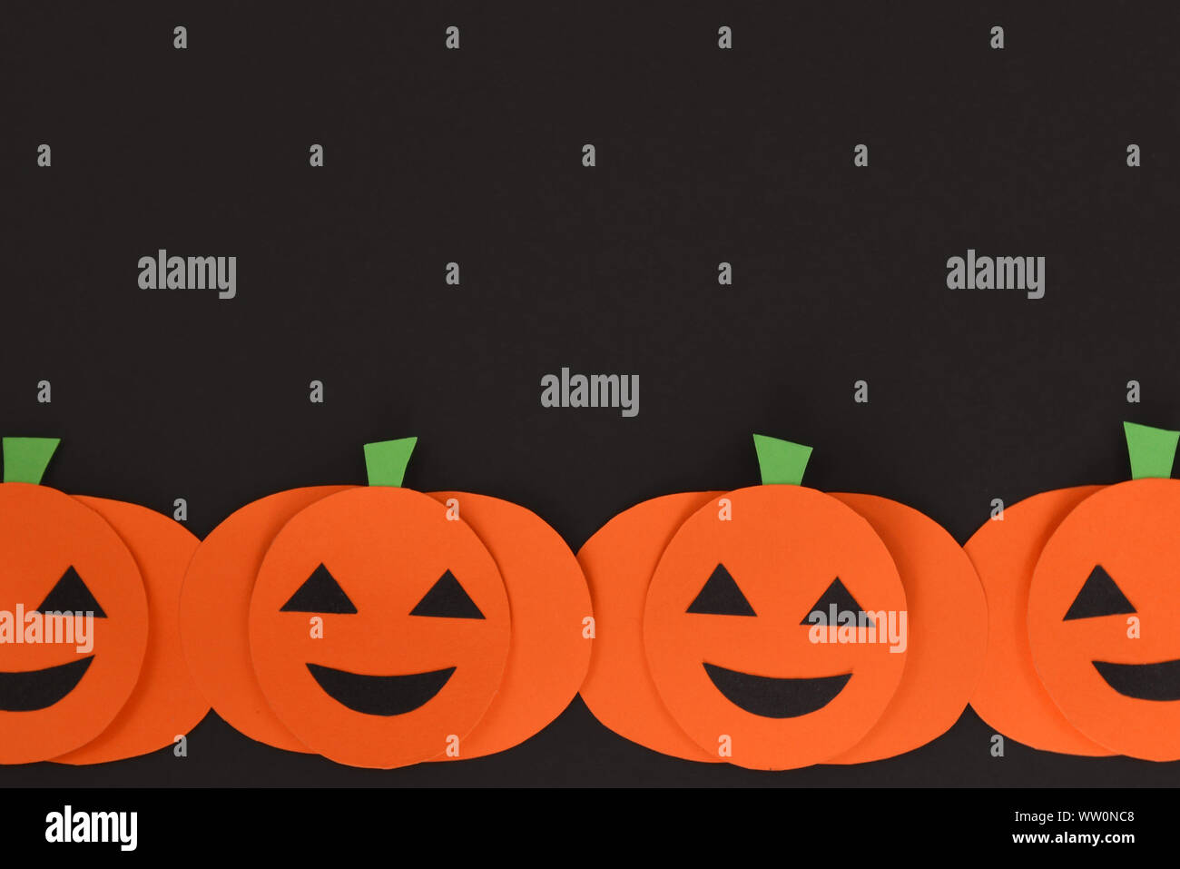 Halloween flat lay background with orange paper crafted carved pumpkins ...