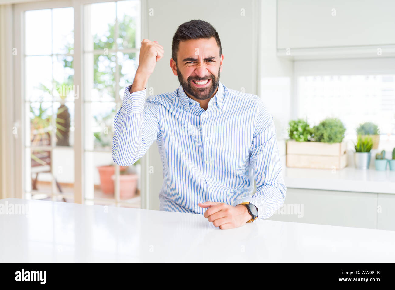 Handsome hispanic business man angry and mad raising fist frustrated ...