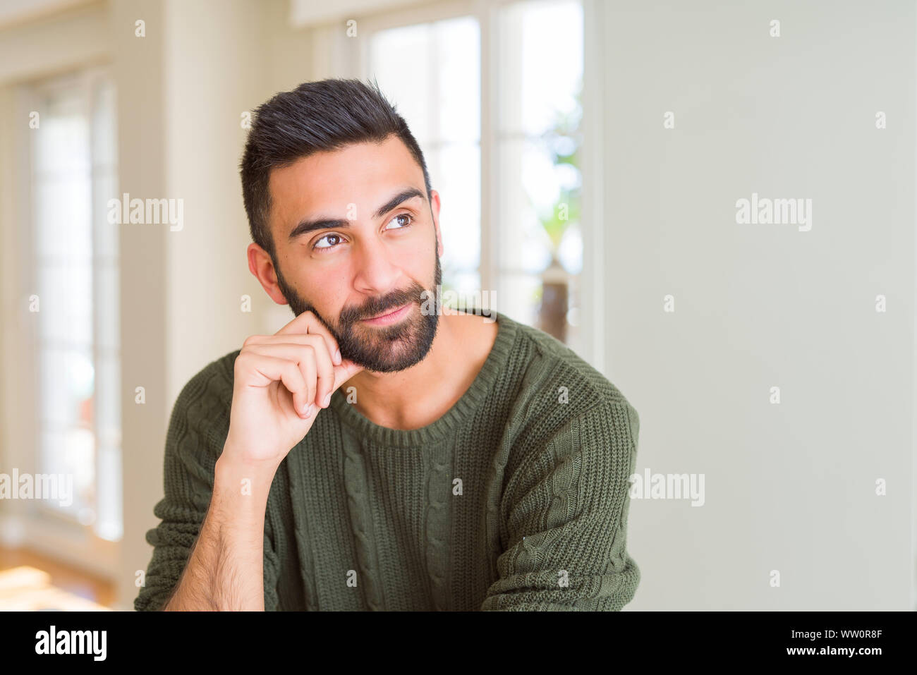 Handsome man thinking confused about doubt, questioning an idea Stock Photo