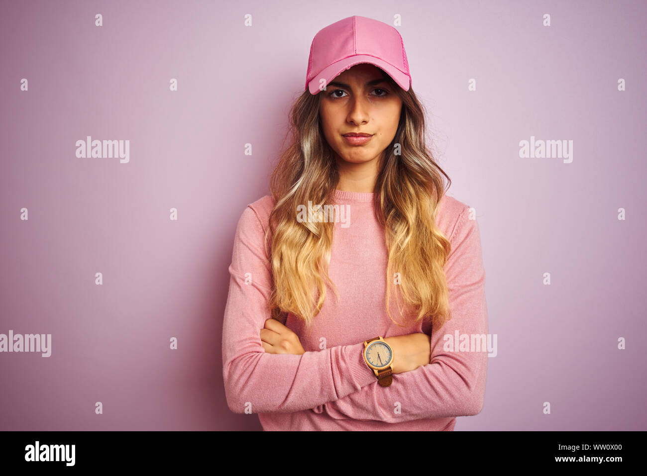 Young beautiful woman wearing cap over pink isolated background skeptic and nervous, disapproving expression on face with crossed arms. Negative perso Stock Photo