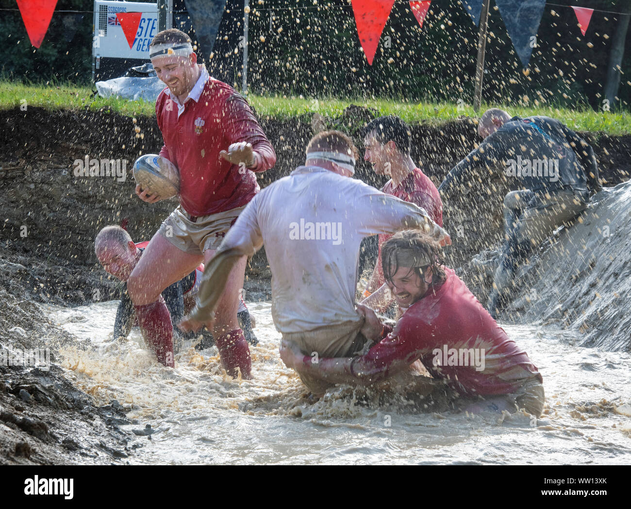 Competitors dressed as England and Wales rugby players on the ‘Mud Mile’ at the Tough Mudder endurance event in Badminton Park, Gloucestershire UK Stock Photo