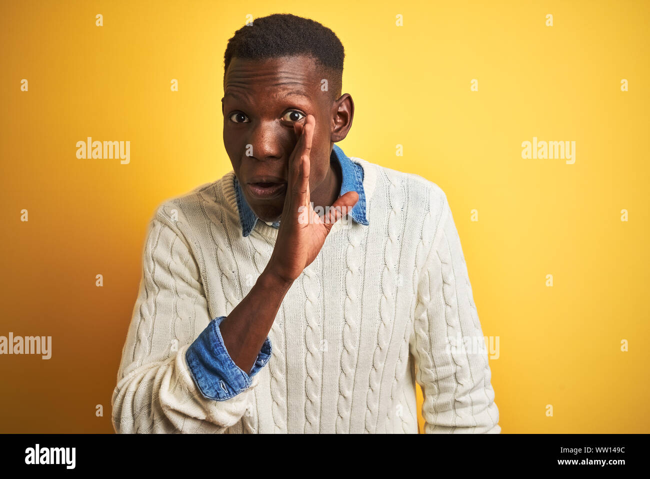 African American Man Wearing Denim Shirt And White Sweater Over Isolated Yellow Background Hand