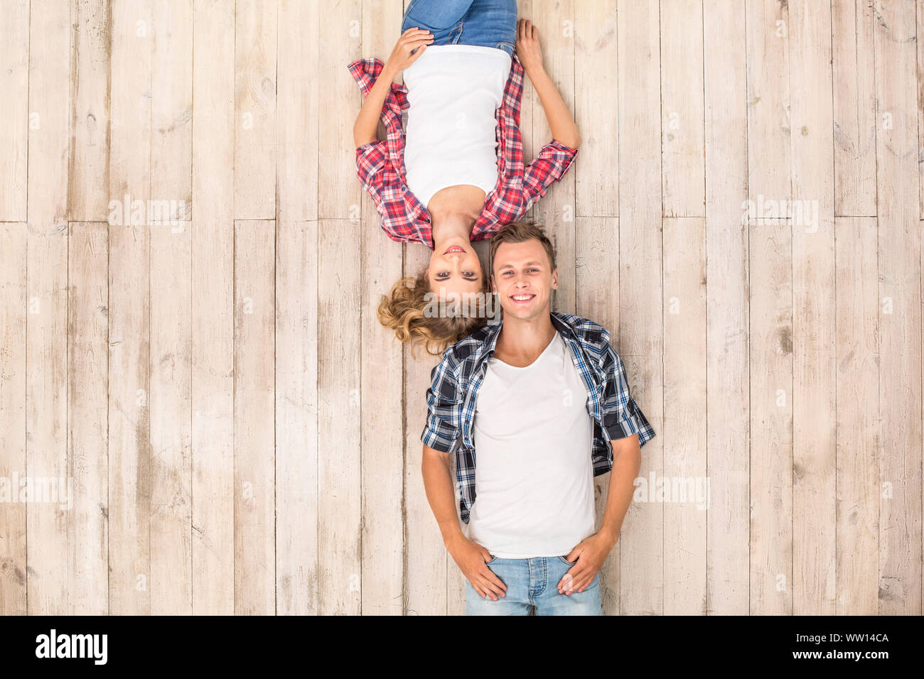 Freestyle. Young man and woman upside down lying on floor smilign happy top view Stock Photo