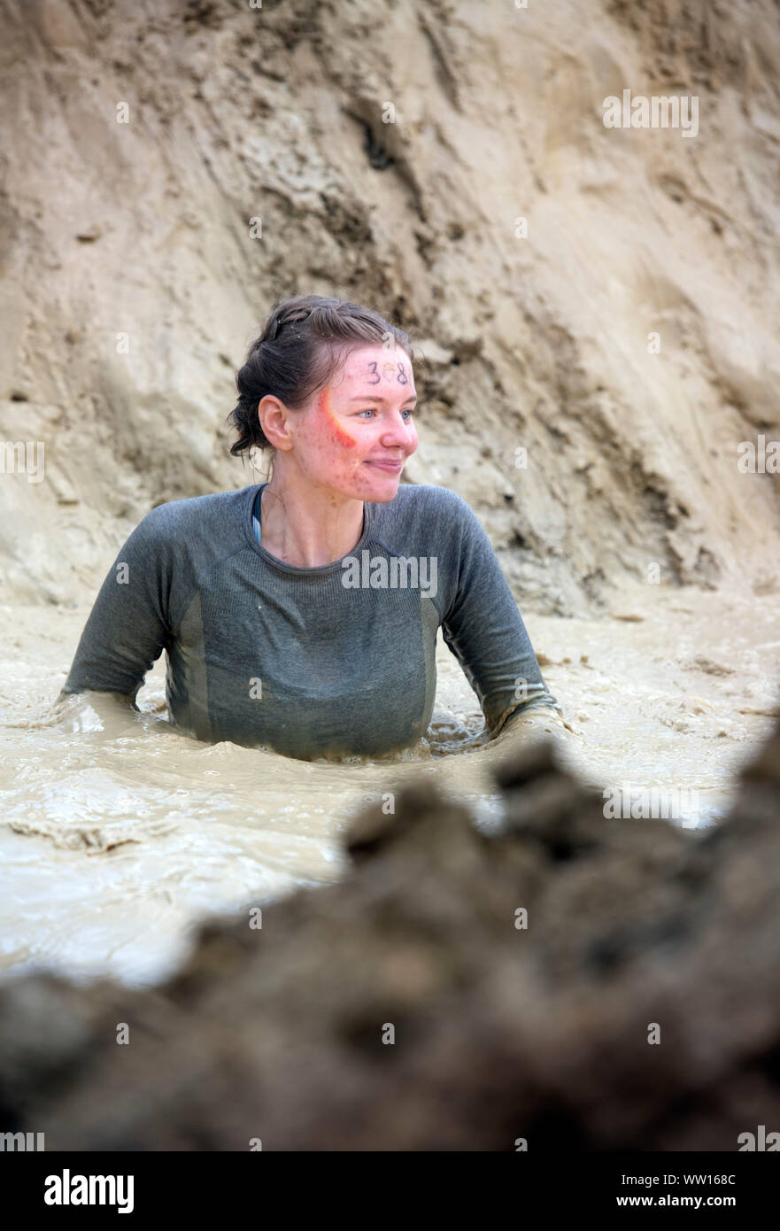 A contestant on the ‘Mud Mile’ at the Tough Mudder endurance event in Badminton Park, Gloucestershire UK Stock Photo