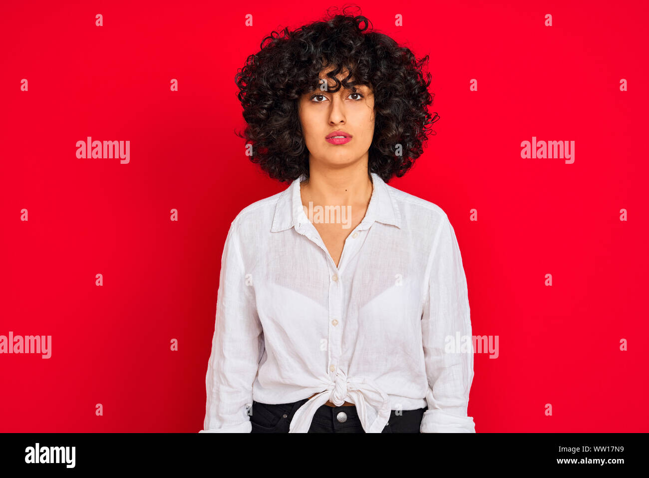 Young Arab Woman With Curly Hair Wearing White Casual Shirt Over