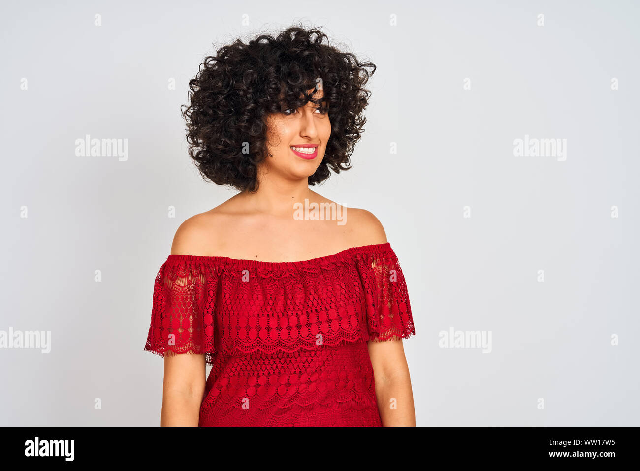 Young Arab Woman With Curly Hair Wearing Red Dress Standing Over
