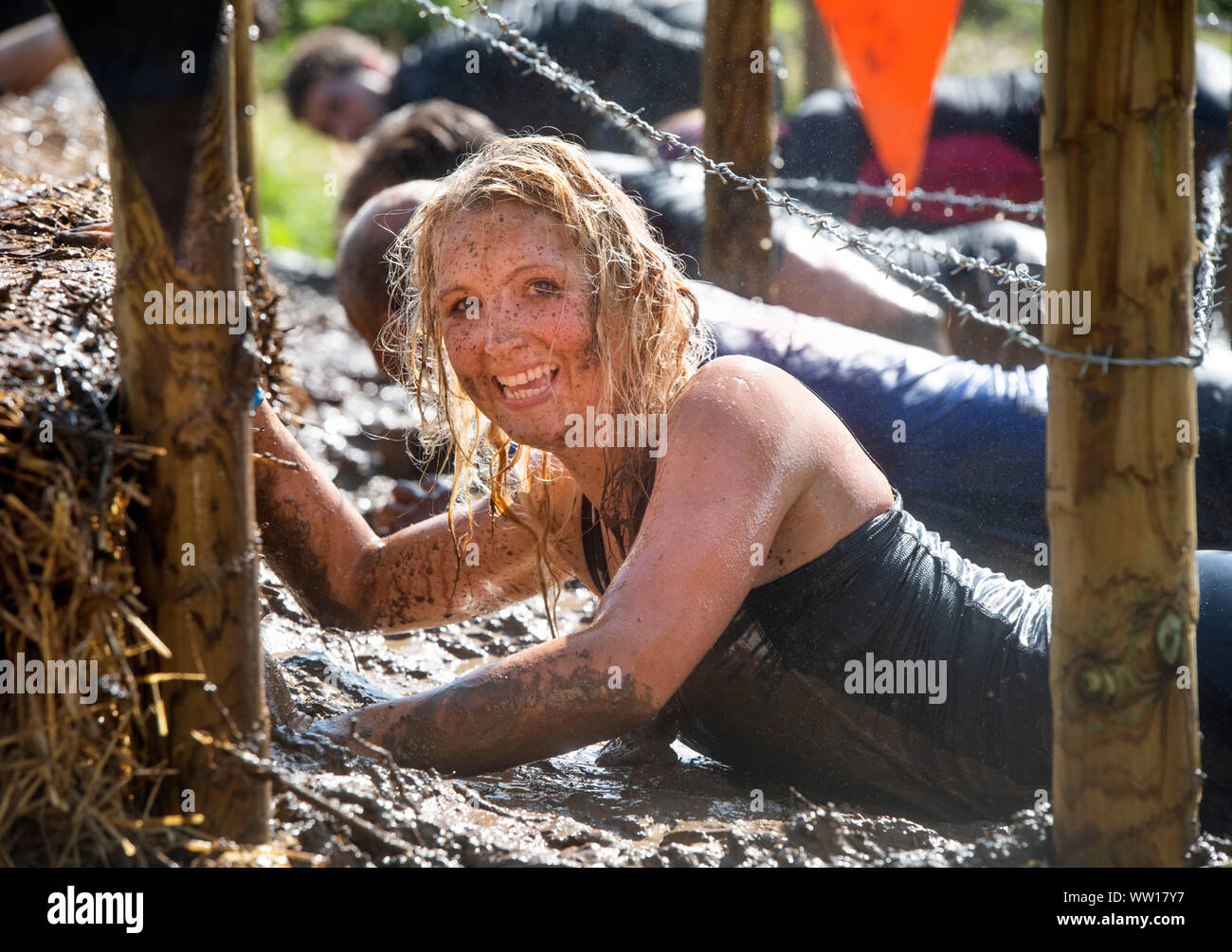 A competitor on the ‘Get Low’ obstacle at the Tough Mudder endurance event in Badminton Park, Gloucestershire UK Stock Photo