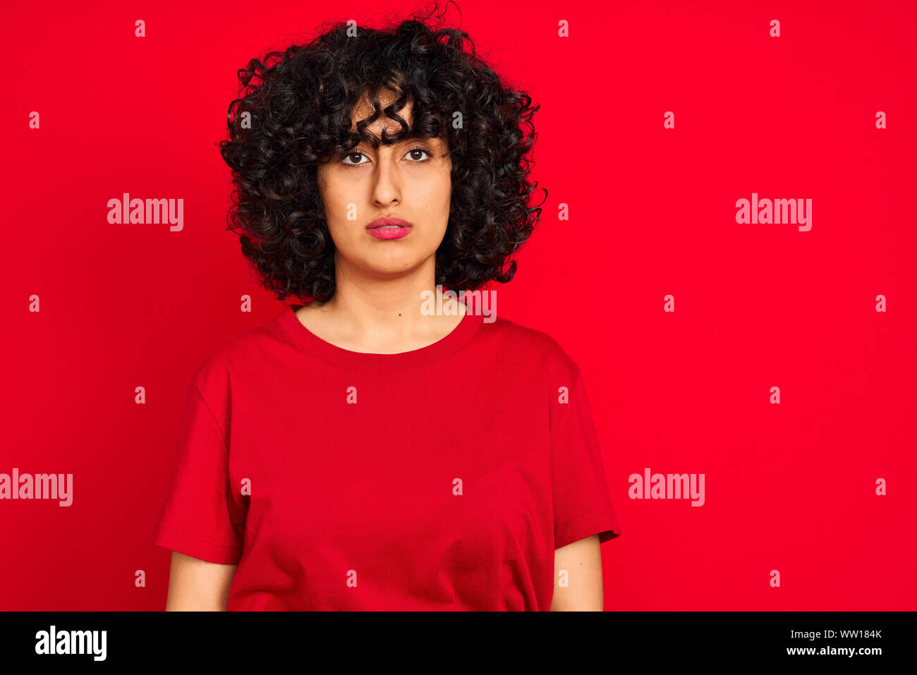 Young Arab Woman With Curly Hair Wearing Casual T Shirt Over