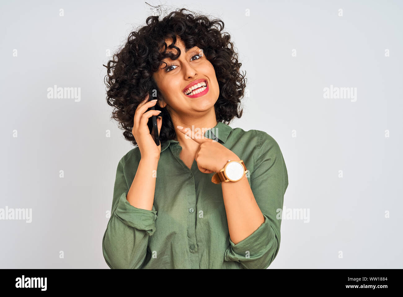 Young Arab Woman With Curly Hair Talking On Smartphone Over