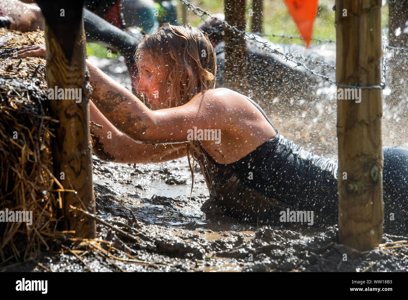 A competitor on the ‘Get Low’ obstacle at the Tough Mudder endurance event in Badminton Park, Gloucestershire UK Stock Photo