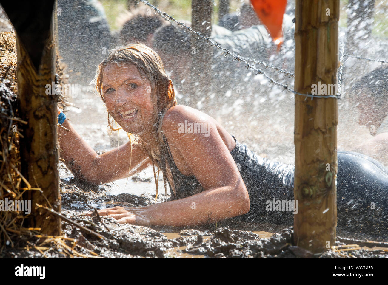 A competitor on the ‘Get Low’ obstacle at the Tough Mudder endurance event in Badminton Park, Gloucestershire UK Stock Photo