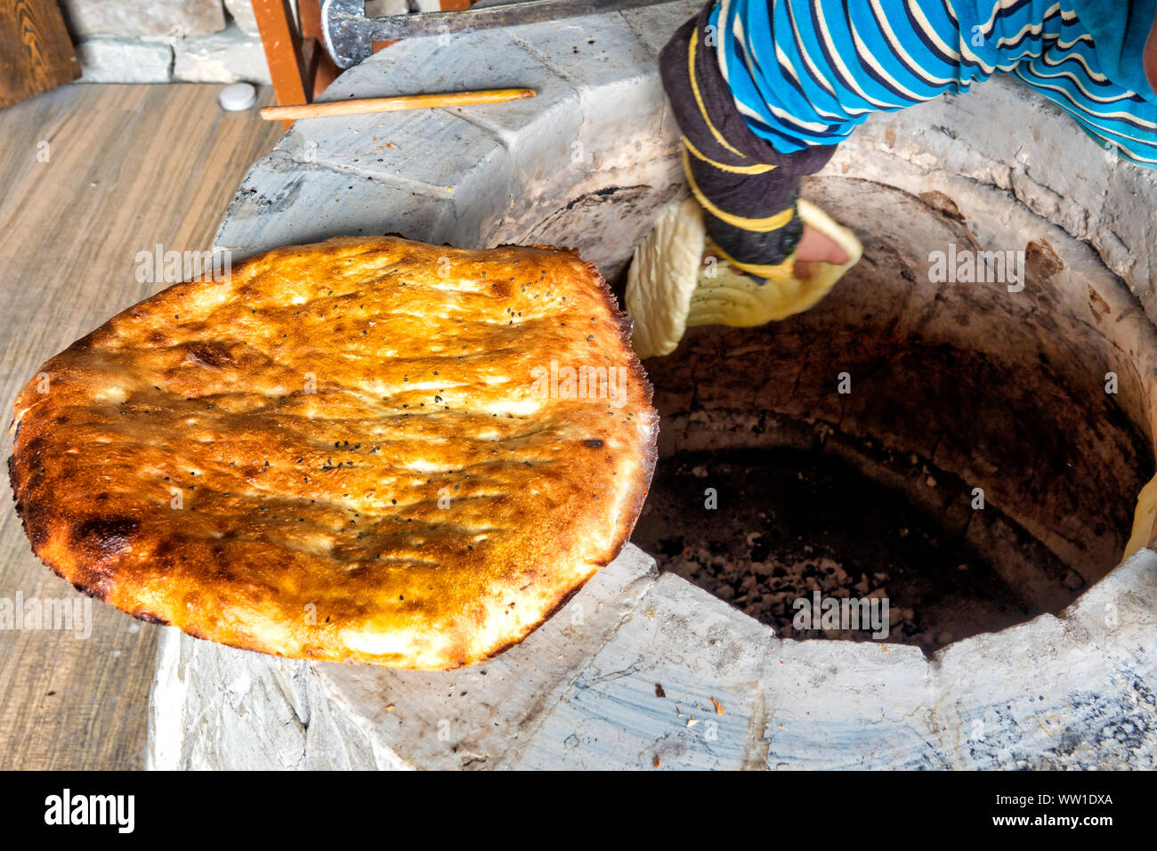 Woman cooking tandir in a traditional tandoor, Damirchi, Azerbaijan Stock Photo