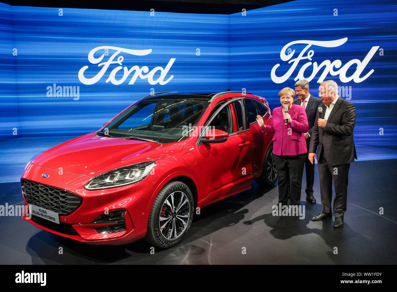 Frankfurt 12.Sept.2019: German Chancellor Angela Merkel visits Ford booth at IAA. From left.: Anglea Merkel, VDA President Bernhard Mattes, Ford Germany boss Gunnar Herrmann, the car is a Ford Kuga Hybrid.   ---   Frankfurt/M 12.9.2019: Bundeskanzlerin Angela Merkel besucht Ford-Stand auf IAA. V.l.n.r.: Anglea Merkel, VDA Präsident Bernhard Mattes, Ford-Werke-Chef Gunnar Herrmann, das Auto ist ein Ford Kuga Hybrid. Stock Photo