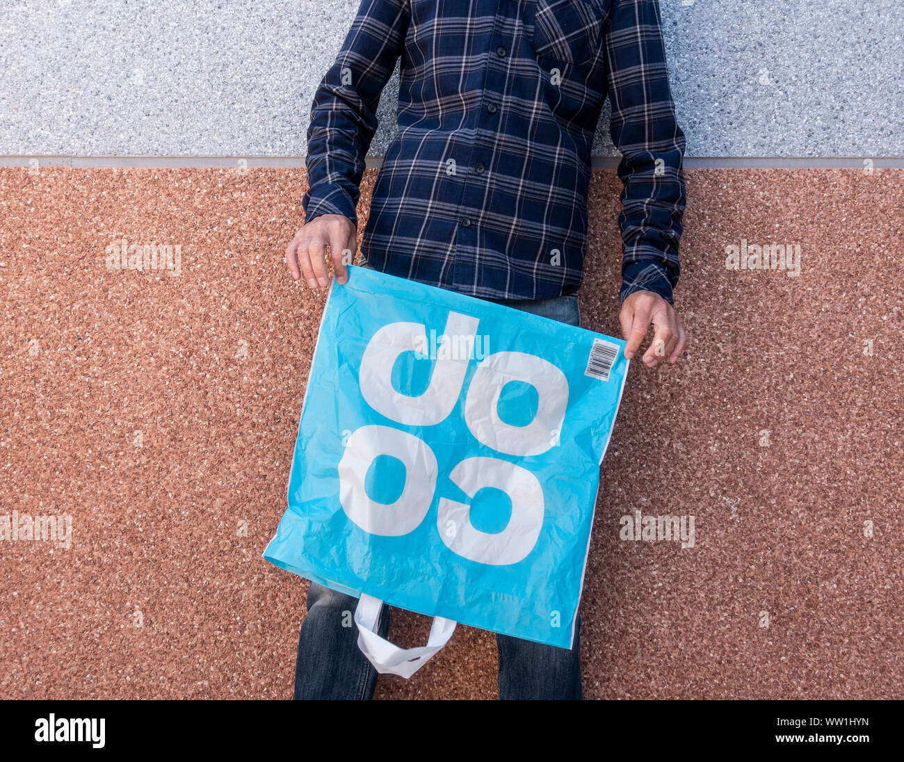 Man holding empty Coop supermarket plastic shopping bag. UK Stock Photo