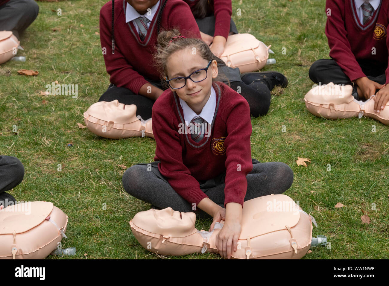 London UK, 12th September 2019 The British Red Cross hosts a demonstration of 100 school children conducting first aid outside the Houses of Parliament to mark the achievement of getting first aid on the school curriculum school girl in uniform works on a resuscitation  doll  Credit Ian DavidsonAlamy Live News Stock Photo