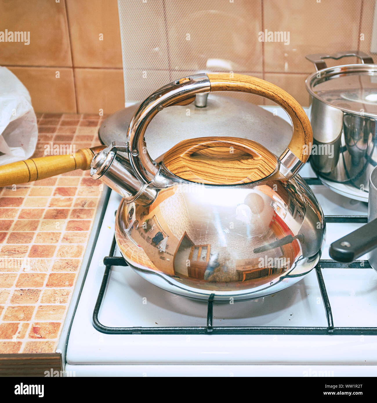 Kettle, saucepans and a frying pan on a gas stove. Dishes in the