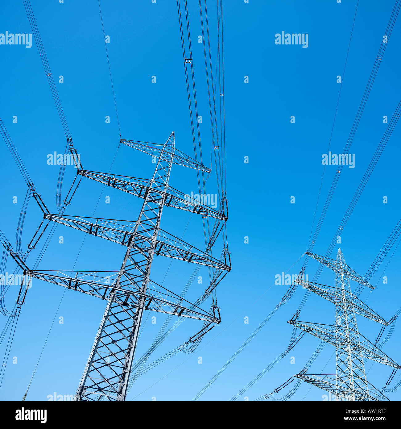 power pylons and electricity wires against blue sky Stock Photo - Alamy