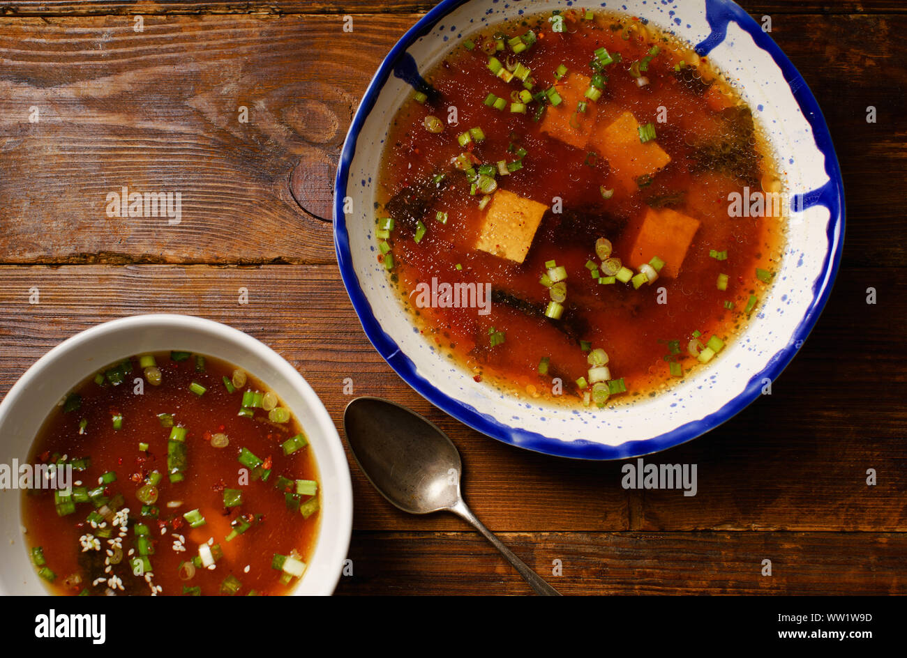 Japanese miso soup with tofu, wakame seaweed, spring onions and pepper flakes Stock Photo