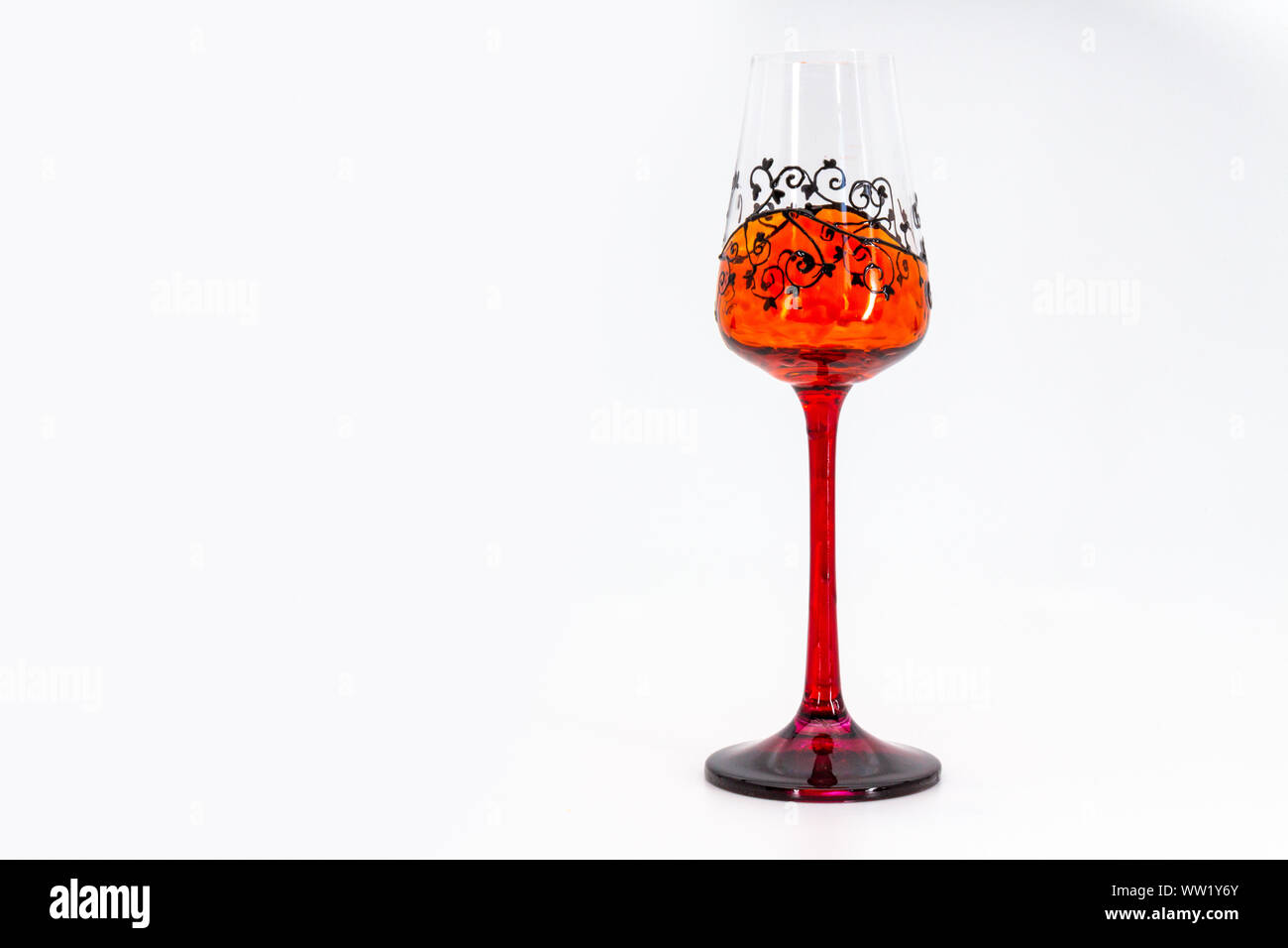 Painted unique ornamented ornate orange grappa glass with copy space Stock Photo