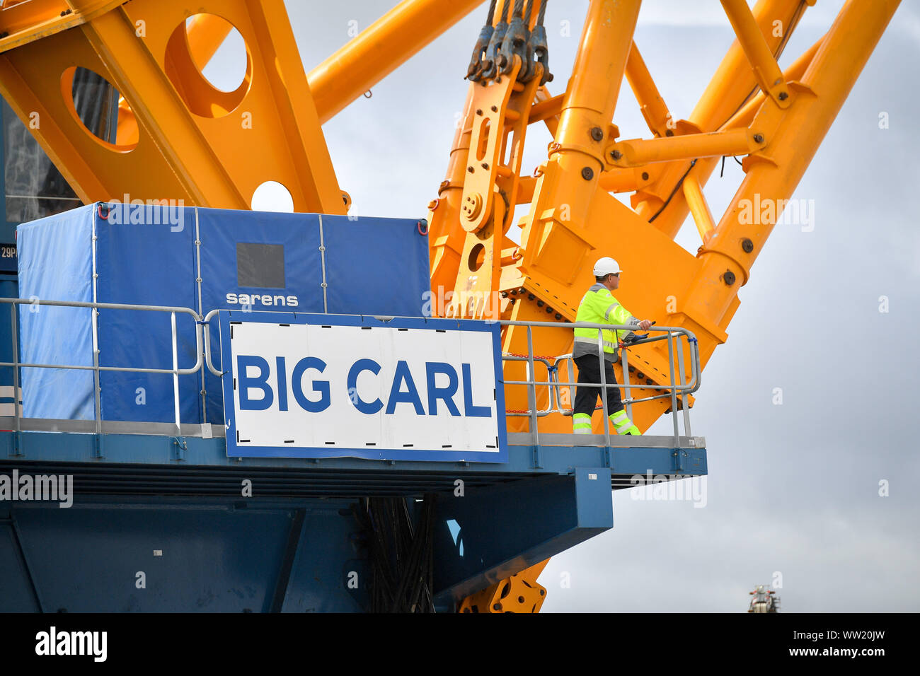 The sign of 'Big Carl', the world's largest crane, which is preparing to begin work at Hinkley Point C power station in Somerset. Able to stand up to 250m tall, the Sarens SCC-250 crane can reach higher than the tallest tower at London's Canary Wharf and can carry 5,000 tonnes in a single lift. Stock Photo