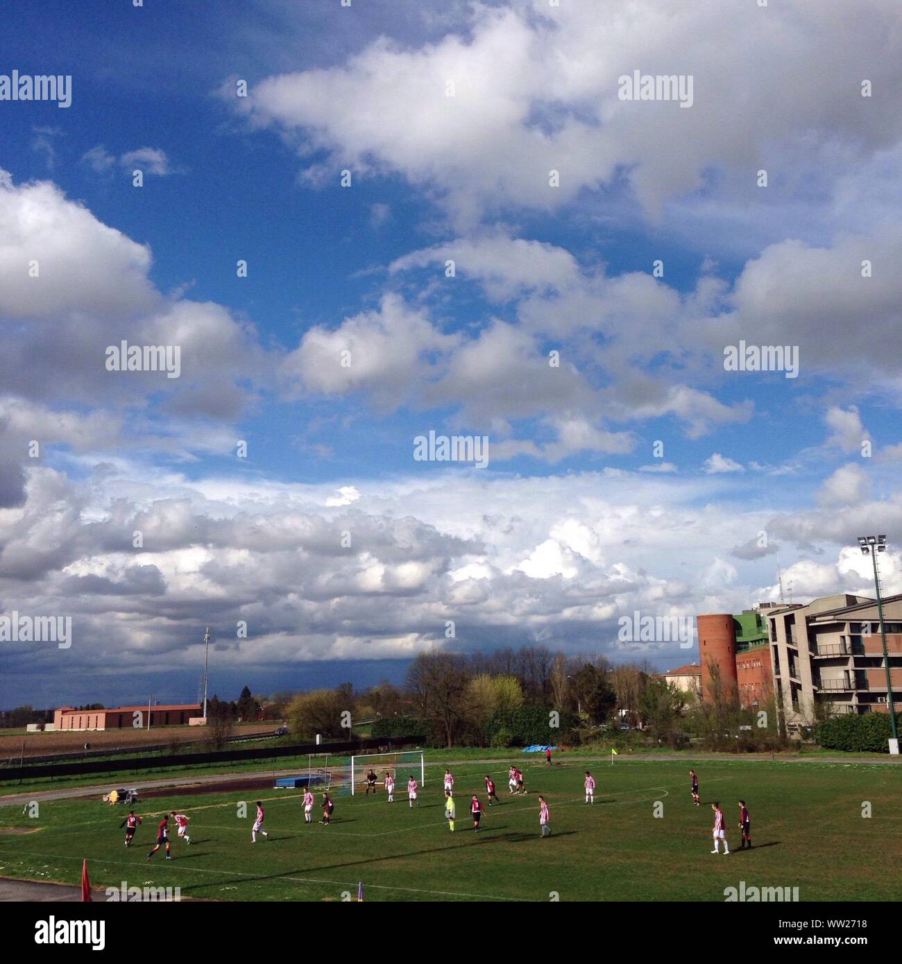 High Angle View Of Sportsmen Playing Soccer Against Cloudy Sky Stock Photo
