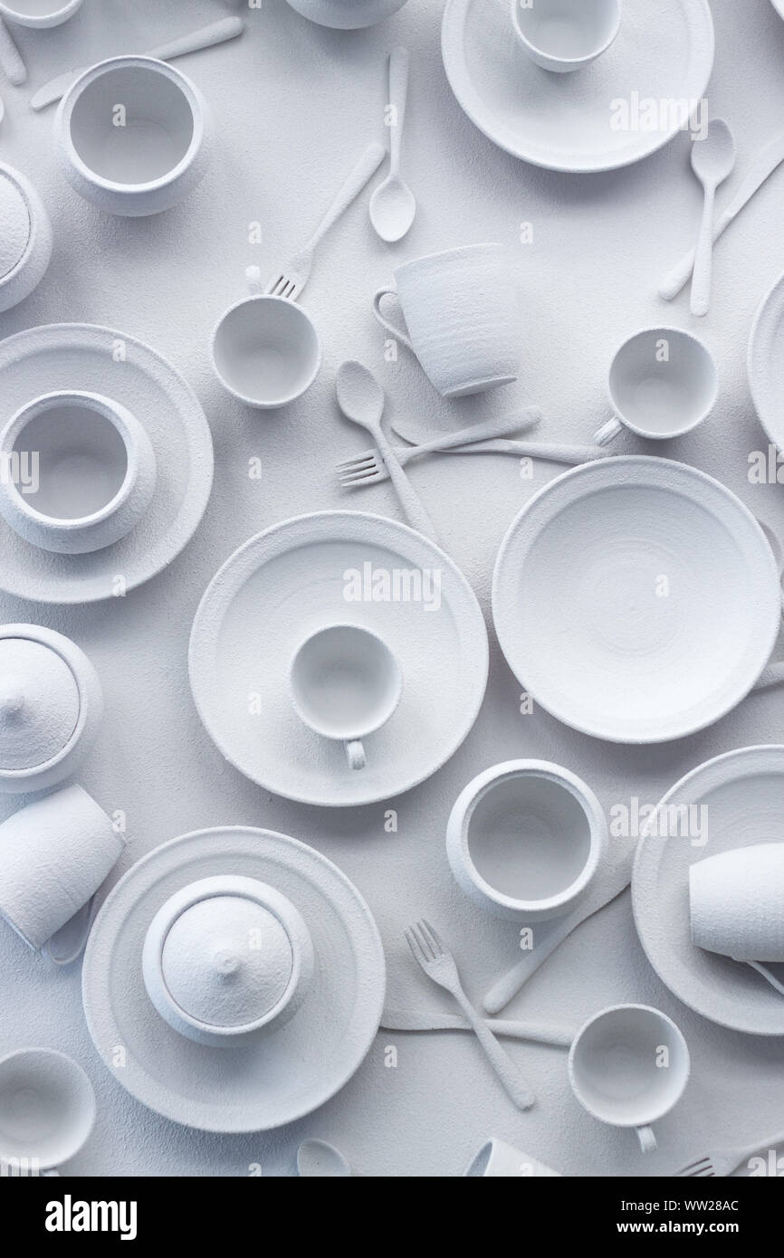 Many dishes and appliances are painted white on white surface, the concept of excessive consumption, selective focus Stock Photo